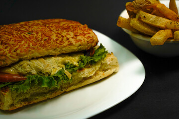 Delicious chicken sandwich on black background