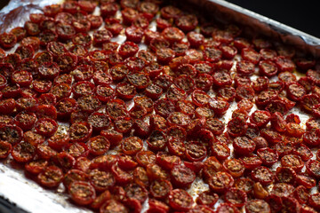 Sun dried tomatoes with fresh herbs and spices. Slate background. Step by step cooking