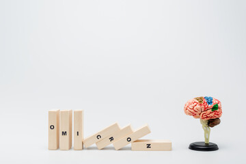 wooden bricks with omicron lettering near brain model on grey background.