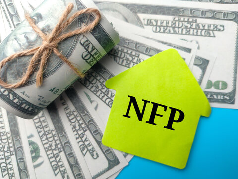 Banknotes and colored notepaper with word NFP on blue background.