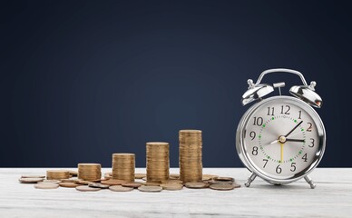 money background, coins and alarm clock on the table, concept of bank deposits,