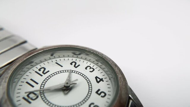 Macro view of wristwatch. Close-up of a worn watch full of scratches on a white background.
