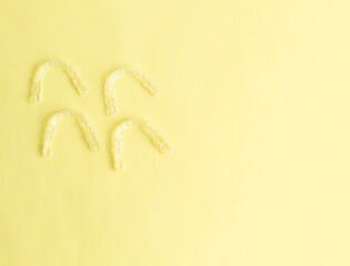 Invisible dental aligners or clear aligners on yellow background. Aesthetic orthodontic treatment performed by the dentist in the clinic ...