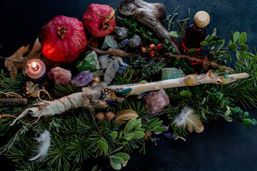 Pomegranates, a magic wand with crystals, burning candles, herb lore, witch story, occult flat lay