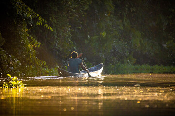 Scenic view of fisherman in canoe at sunrise on the river - obrazy, fototapety, plakaty