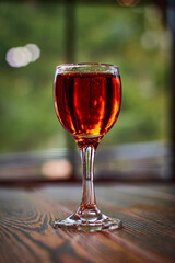 Glass of cognac on wooden table. Shot glass.