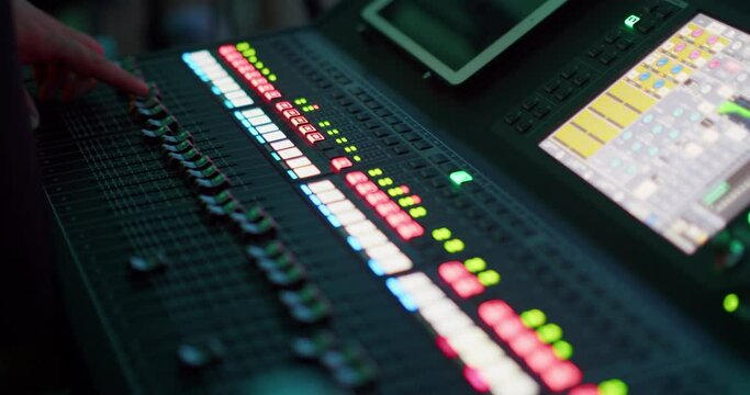 Sound Engineer Hand Controlling Audio on Mixer Console at Live Music Concert. Sound technician professional Works on Mixing Board in Studio or at Night Party. 4K close up handheld shot in slow motion