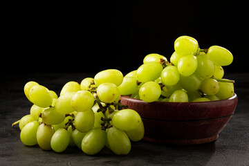 Fresh green grapes in wooden bowl.