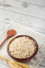 Oat flakes in wooden bowl.