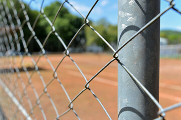 Close-up grids of a tennis court and the blur of a sunny day on the back. Inviting athletes for a game.