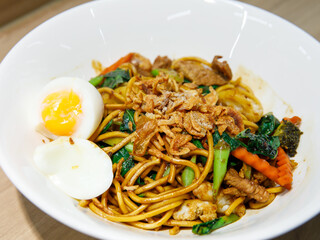 Stir fried yellow noodle Mee pad hokkian phuket, rice yellow noodle with soy sauce, pork, vegetables and egg. Thai food phuket