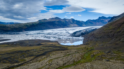 Beautiful Cinematic Aerial view of the massive Svinafellsjokull Glacier in Iceland and its lagoon caused by global warming