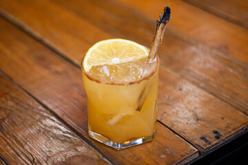 Bebida de naranja con canela sobre mesa de madera 