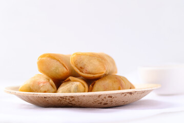 Asian deep fried spring roll filling with tofu, cabbage, carrot and glass noodle on natural plate with white background. Vegan food
