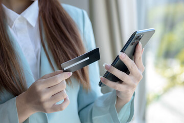 Asian woman using credit card with mobile phone for online shopping, technology money wallet and...