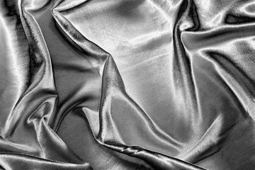 Abstract background with silver silk fabric texture. Luxurious flowing silver textile