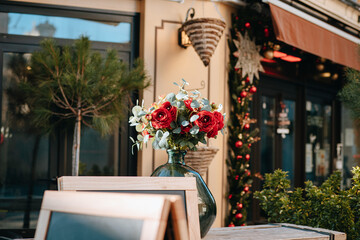 Photos of pink and green flower bouquet/bunch in a vase on an outdoor table with decorations around 
