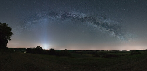 Panorama of the Milky Way bow over rural landscape with fields
