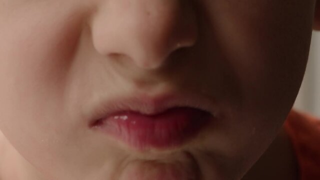 Close up of a child's mouth making a defiant expression.
