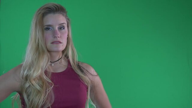 Beautiful Blonde Woman in Red Tank Top Flips Hair and Poses For Camera in Front of Green Screen - Powered by Adobe