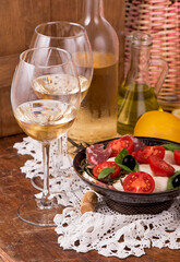 white wine and tomatoes with basil. Wine and tomatoes with basil in vintage setting on wooden table