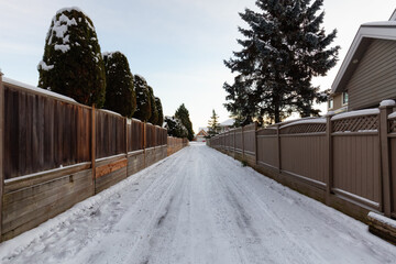 Alley with Snow in a residential neighborhood in the city suburbs. Surrey, Greater Vancouver, British Columbia, Canada. Colorful Winter Sunrise After Snowfall