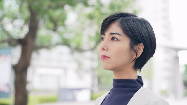 街中で空を見上げる女性