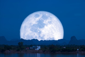 Full Snow Moon on night sky back silhouette mountain hill over lake