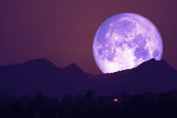 Fototapeta na wymiar rose moon on night sky back over silhouette mountain