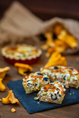 Mushroom pie with chanterelles lying on a wooden background and decorated with ginger mushrooms at the edges