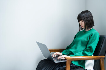 部屋でパソコンを使う女性