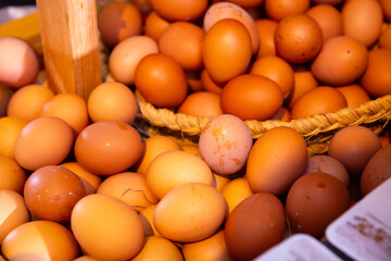 Image of raw fresh eggs in wicker basket at grocery store, nobody