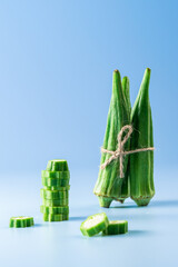 Close up view of  fresh okra  vegetable isolated on blue background.