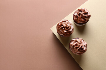 Tasty chocolate cupcakes on brown background