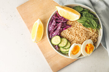 Healthy quinoa bowl with egg on light table