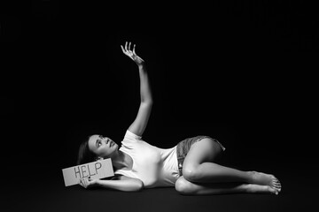 Scared young woman on dark background. Violence concept