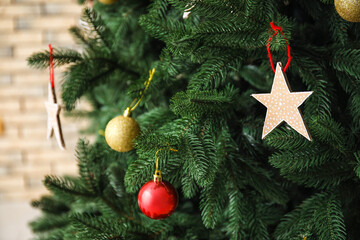 Star made of cardboard hanging on Christmas tree, closeup