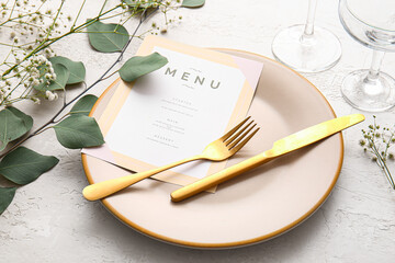 Beautiful table setting for wedding with menu and gypsophila flowers on light background