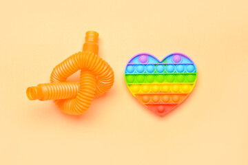 Colorful Pop Tube and Pop it fidget toy on beige background