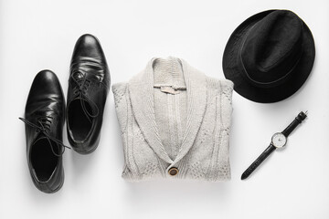 Knitted male sweater, shoes, hat and wristwatch on white background