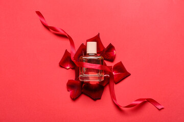 Perfume and rose petals for Valentine's day on red background