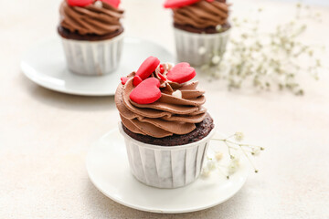 Plates with tasty chocolate cupcakes for Valentine's Day on white background