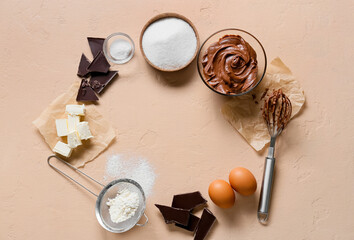 Fototapeta na wymiar Frame made of ingredients for preparing chocolate brownie on beige background