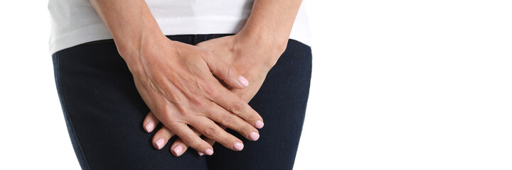 Young sick woman holds hands pressing to perineum to lower abdomen - obrazy, fototapety, plakaty