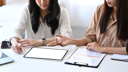 Fototapeta premium Businesswoman sharing ideas or startup business plan on digital tablet to her colleague.