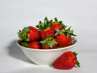 A bowl with fresh strawberries on white background