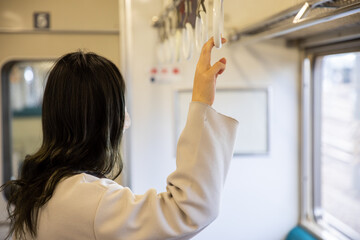 Fototapeta premium つり革に捕まる女性 go to work