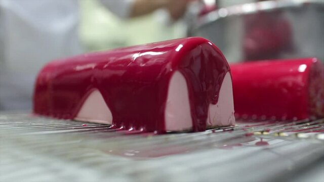 chef pouring red glaze over log glacage buche