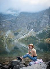 Young woman on a hiking trip sitting on a rock