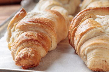 Close-up view of homemade croissants on a baking paper. Selective focus.